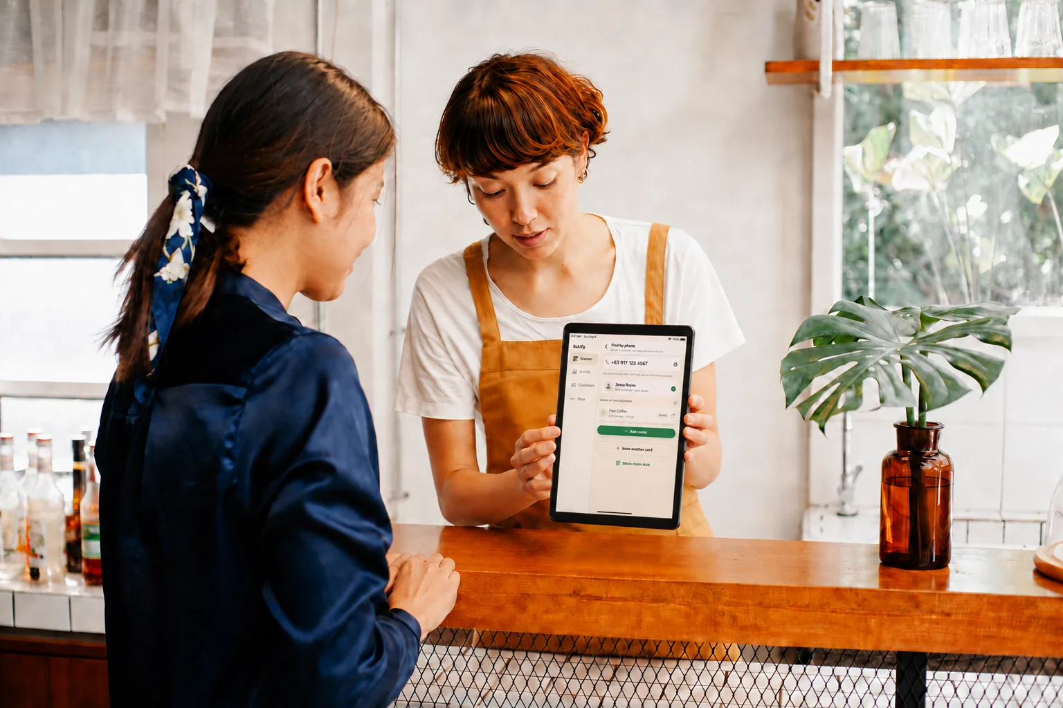 A clerk confirming a newly issued stamp card on a tablet